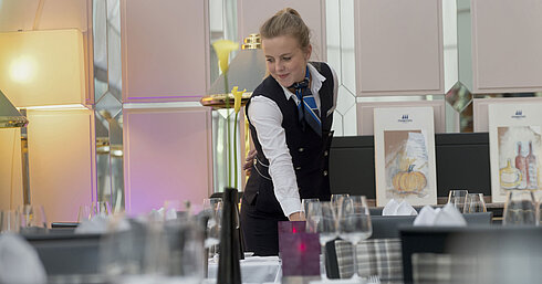 Maritim Conference Service Staff member elegantly sets the table in the restaurant at the Maritim Hotel Munich