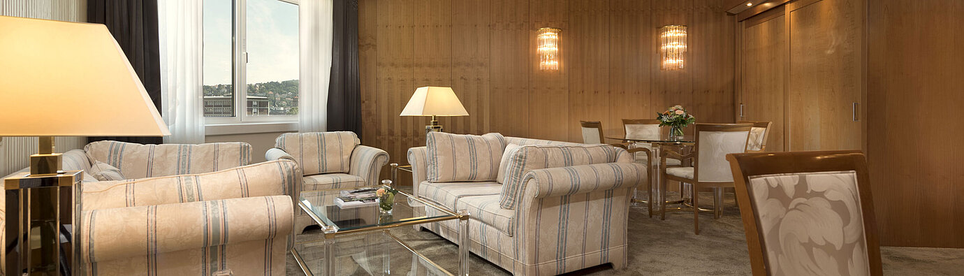 Suite Classic Sala de estar amplia con gran ventana y zona de estar en el Maritim Hotel Stuttgart