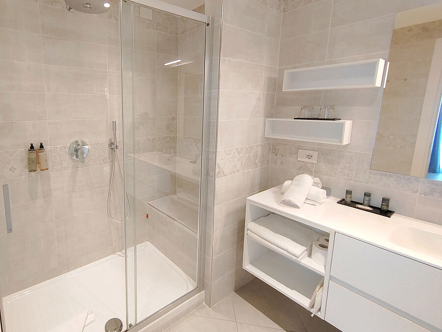 Bathroom Spacious bathroom at Maritim Resort Calabria with rain shower, white furniture and open layout