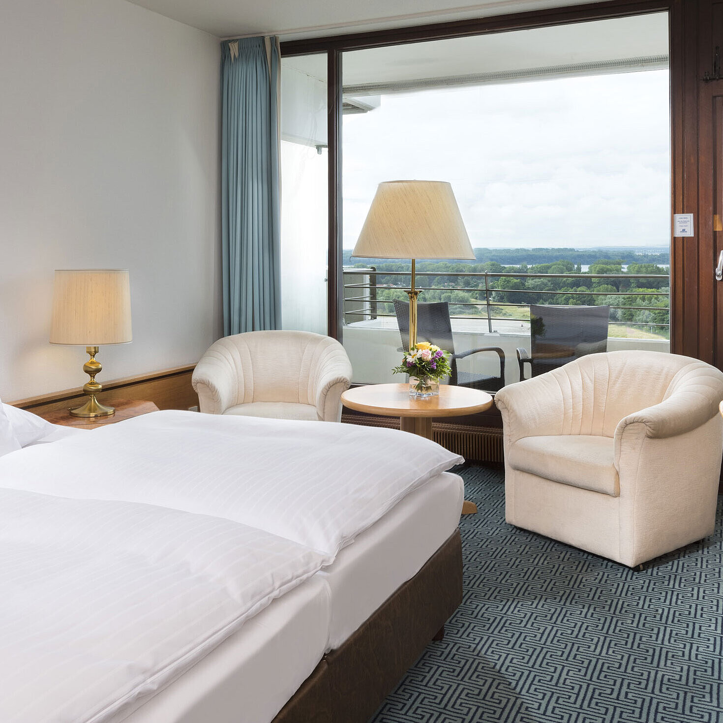 ComfortPlus room Double room with seating area, desk and balcony overlooking green landscape in Travemünde