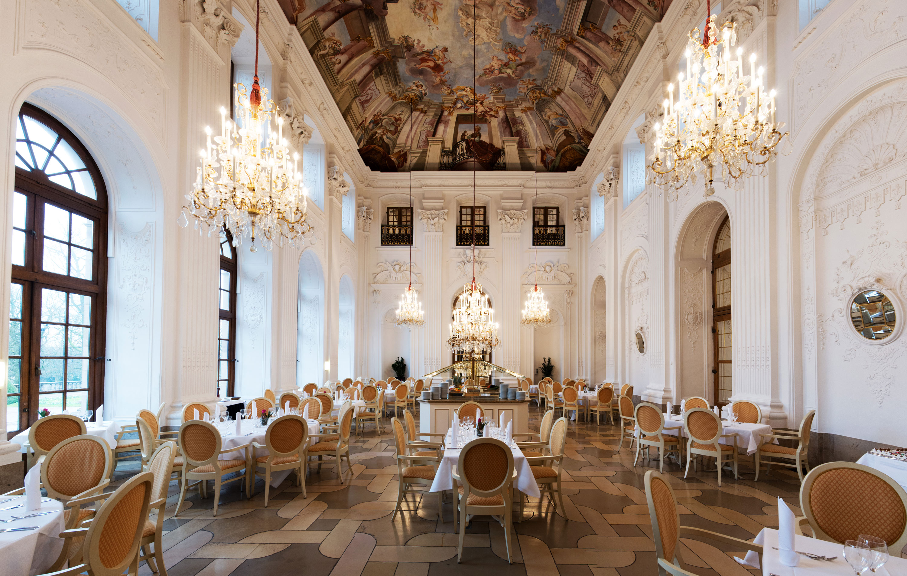 Apollo Saal Restaurant Elegant Apollo Hall at Maritim Hotel Fulda with chandeliers, fresco ceiling, and stylishly set tables.