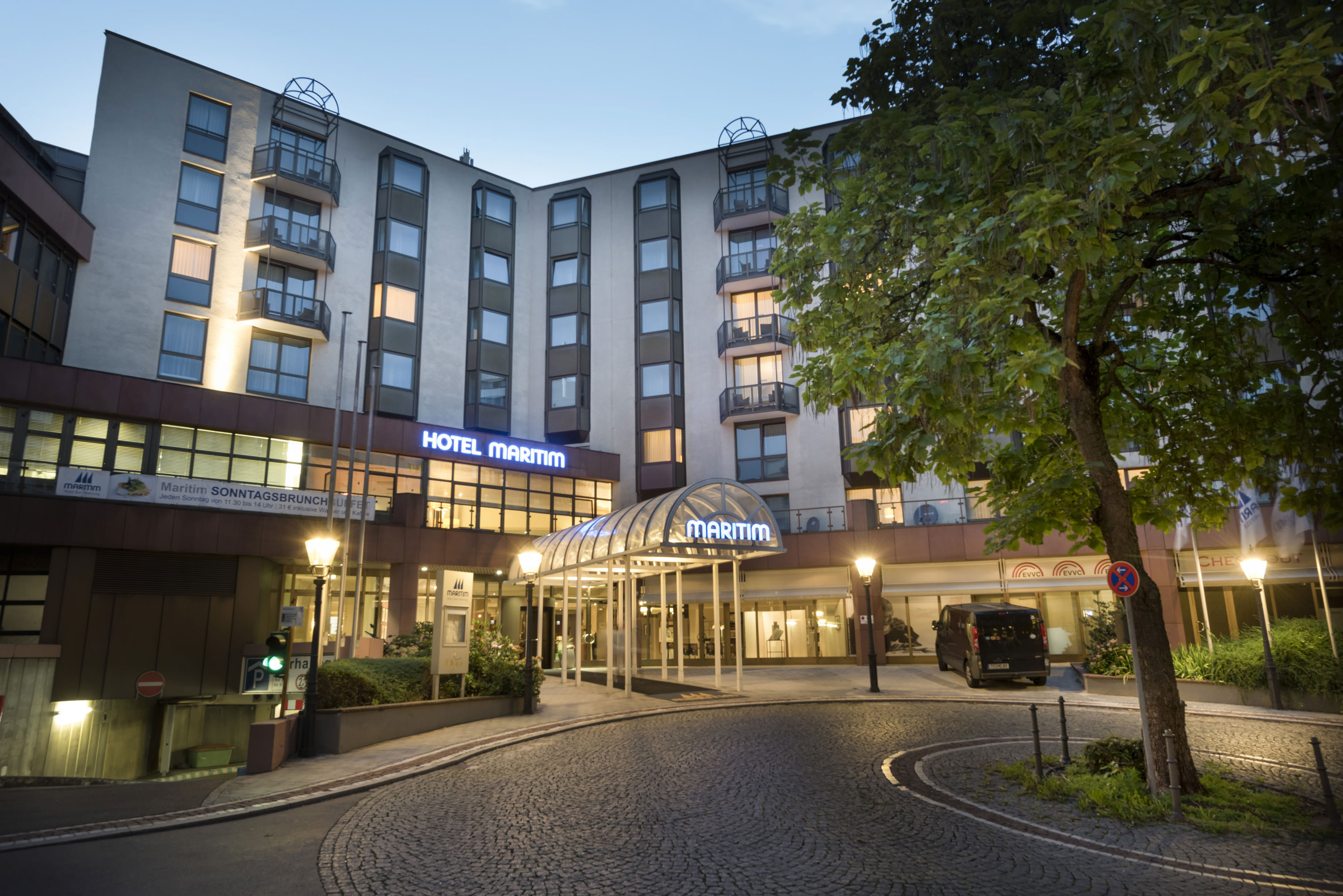 Exterior view at night Atmospheric hotel entrance of Maritim Hotel Bad Homburg at dusk with lighting.