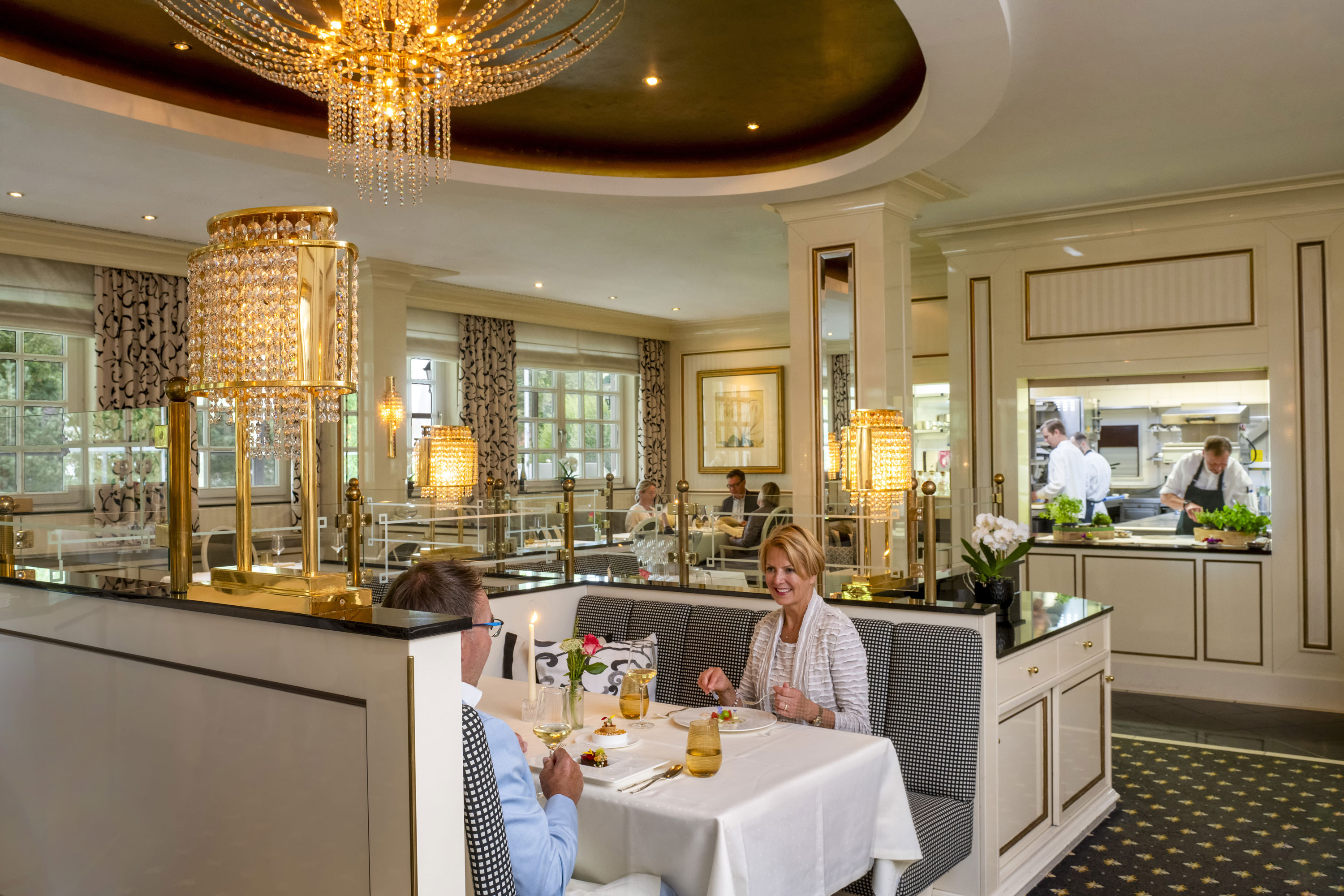Orangerie Restaurant Couple enjoying a fine dinner at the luxurious Orangerie restaurant in Maritim Timmendorfer Strand with a view of the kitchen